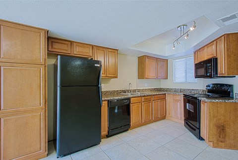 a kitchen with black appliances and wooden cabinets